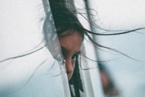 child looking out window worries about natural disasters